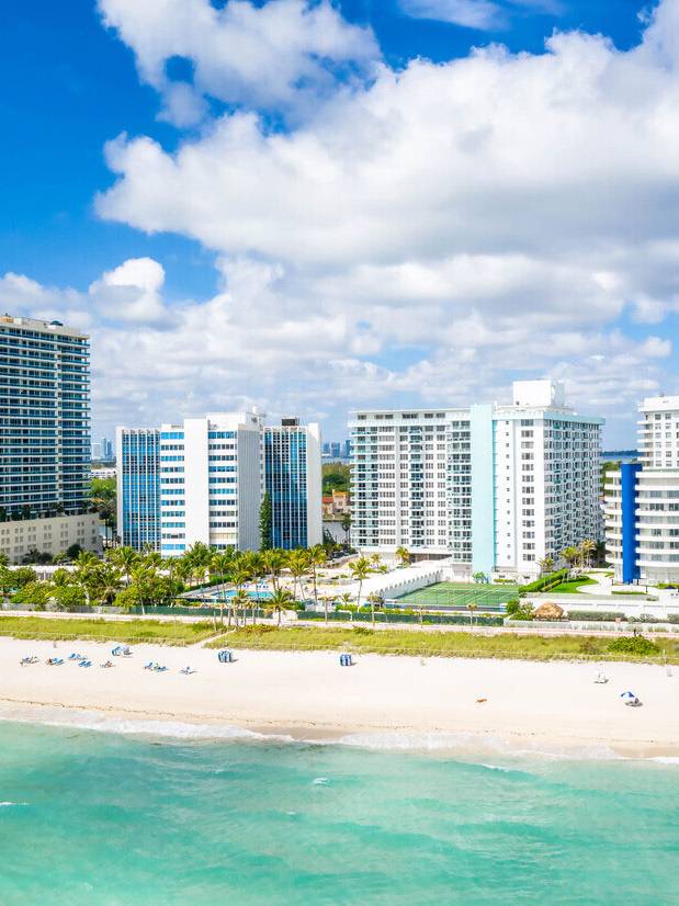 Book direct & Save Aerial view of Seacoast Suites building and Miami Beach